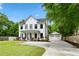 Inviting two-story farmhouse-style home with a charming front porch and well-manicured lawn, showcasing classic American architecture at 1872 Rifle Range Rd, Mount Pleasant, SC 29464