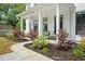 Charming front porch featuring classic columns, a cozy seating area, and beautifully landscaped surroundings enhancing curb appeal at 1872 Rifle Range Rd, Mount Pleasant, SC 29464