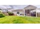 View of the backyard and screened-in porch, with a well-maintained lawn and landscaping for outdoor enjoyment at 2022 Elvington Rd, Johns Island, SC 29455