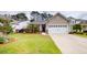 Charming home exterior with a lush green lawn, beautiful landscaping, and a spacious driveway leading to a two-car garage at 2022 Elvington Rd, Johns Island, SC 29455