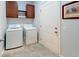 Laundry area with a white washer and dryer, upper cabinets, and tile floors at 2022 Elvington Rd, Johns Island, SC 29455