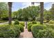 Landscaped front yard with mature trees and a charming brick path leading to the home at 2050 Wappoo Hall Rd, Charleston, SC 29412