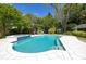 Backyard swimming pool with hot tub, surrounded by white tile, lush yard and mature landscaping at 2050 Wappoo Hall Rd, Charleston, SC 29412