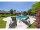 Backyard view of swimming pool and hot tub with lounge chairs and lush surrounding landscaping at 2050 Wappoo Hall Rd, Charleston, SC 29412