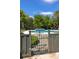 Swimming pool and hot tub beyond an iron gate, and wooden fence surrounded by lush landscaping at 2050 Wappoo Hall Rd, Charleston, SC 29412