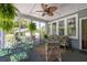 Relaxing screened porch with a ceiling fan, dining set and exterior views at 2050 Wappoo Hall Rd, Charleston, SC 29412