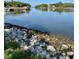 Scenic water view of a calm river or inlet with rocky shoreline and lush greenery in the distance at 2050 Wappoo Hall Rd, Charleston, SC 29412