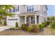 Inviting front porch featuring a rocking chair and well-maintained landscaping and white garage at 209 Palmetto Walk Dr, Summerville, SC 29486