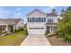 Charming two-story home featuring a white garage door and beautiful landscaping, curb appeal at 209 Palmetto Walk Dr, Summerville, SC 29486