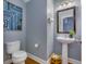 Powder room with a pedestal sink, modern mirror, and stylish blue artwork at 209 Palmetto Walk Dr, Summerville, SC 29486