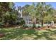 Back exterior of a two-story gray home featuring a slide leading to a swimming pool surrounded by mature palm trees at 2225 Black Oak Court, Mount Pleasant, SC 29466