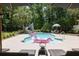 Beautiful backyard pool with a slide, lounge chairs, tropical plants, and lush greenery at 2225 Black Oak Court, Mount Pleasant, SC 29466