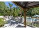 Relaxing backyard deck, partially covered with white railing, overlooks the fabulous pool and tropical landscape at 2225 Black Oak Court, Mount Pleasant, SC 29466