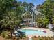 Lovely backyard with a gunite pool, waterslide, lounge chairs, and mature palms offers a luxurious feel at 2225 Black Oak Court, Mount Pleasant, SC 29466