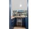 Chic bar area with a wine refrigerator, stylish cabinetry, and open shelving with decorative wallpaper at 2225 Black Oak Court, Mount Pleasant, SC 29466