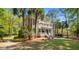 Elegant two-story home with a double porch, surrounded by lush greenery and mature palm trees at 2225 Black Oak Court, Mount Pleasant, SC 29466