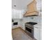 Contemporary kitchen with a stainless steel range, custom hood, and herringbone tile backsplash at 2225 Black Oak Court, Mount Pleasant, SC 29466