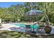 Beautiful outdoor pool area with an umbrella, two lounge chairs, a slide, and surrounded by lush greenery at 2225 Black Oak Court, Mount Pleasant, SC 29466