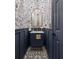 This powder room includes designer wallpaper, black and white tile floor, and a stylish navy vanity at 2225 Black Oak Court, Mount Pleasant, SC 29466