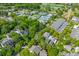 A coastal community features lush trees, rooftops, and recreational spaces like tennis courts at 225 Delahow St, Daniel Island, SC 29492