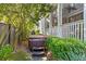 Backyard view of a relaxing hot tub with wooden stairs, surrounded by lush greenery at 225 Delahow St, Daniel Island, SC 29492