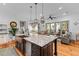 Gourmet kitchen with island sink, stainless appliances, and seamless flow to the living area at 225 Delahow St, Daniel Island, SC 29492
