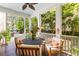Charming covered patio with comfortable seating, ceiling fan, and lush greenery views at 225 Delahow St, Daniel Island, SC 29492
