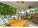 Covered back porch has a ceiling fan and seating area, looking out to the pool and green backyard at 229 Twin Lake Dr, Summerville, SC 29483