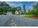 Exterior view of the house with a gravel driveway, storage shed, and detached garage at 229 Twin Lake Dr, Summerville, SC 29483