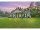 Charming single-story home featuring a covered porch with rocking chairs and lush green lawn at 229 Twin Lake Dr, Summerville, SC 29483