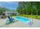 Backyard has a pool with chairs and a storage shed surrounded by trees and green landscape at 229 Twin Lake Dr, Summerville, SC 29483