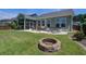 Large backyard featuring a stone fire pit, patio, hot tub, and well-maintained lawn at 234 Basket Grass Ln, Summerville, SC 29486