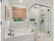 Luxurious bathroom with a soaking tub, frameless shower, and elegant marble tiling at 238 Silk Oak Dr, Moncks Corner, SC 29461