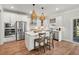Modern white kitchen with stainless steel appliances, a central island, and stylish pendant lighting at 238 Silk Oak Dr, Moncks Corner, SC 29461