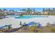 A large community pool surrounded by a concrete deck, landscaping, and comfortable lounge chairs at 306 Lucca Dr, Summerville, SC 29486