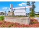Beautifully landscaped entrance to the Woodwinds community with brick sign and flowering plants in foreground at 306 Lucca Dr, Summerville, SC 29486