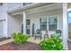 Inviting front porch with seating, decorative plants, and an elegant wreath on the front door at 306 Lucca Dr, Summerville, SC 29486