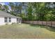 Grassy backyard featuring a covered porch, privacy fence, and lush surrounding trees at 3121 Harding Ct, Johns Island, SC 29455