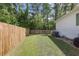 Well-maintained backyard with privacy fence, green grass, and mature trees along the property line at 3121 Harding Ct, Johns Island, SC 29455