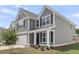 Charming two-story home featuring a well-maintained lawn, gray siding, and a two-car garage at 319 Abercom Place Dr, Moncks Corner, SC 29461