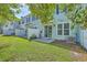 Backyard featuring green grass, a white fence, and a sliding glass door leading to the home's interior at 3367 Eastman Dr, Mount Pleasant, SC 29466