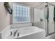 Bright bathroom featuring a garden tub with chrome fixtures and a tiled shower with glass enclosure at 3537 Galaxy Rd, Ladson, SC 29456