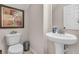 Well-maintained half bathroom featuring a pedestal sink, toilet, and decorative art at 3537 Galaxy Rd, Ladson, SC 29456
