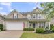 Inviting two-story home featuring a covered front porch and a well-maintained lawn with garden beds at 3537 Galaxy Rd, Ladson, SC 29456