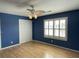 Bedroom featuring stylish blue walls, hardwood floors, a ceiling fan, and bright natural light through shuttered windows at 36 Forde Row, Charleston, SC 29412