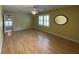 Bedroom featuring yellow walls, hardwood floors, a ceiling fan, and bright natural light through shuttered windows at 36 Forde Row, Charleston, SC 29412