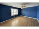 Bedroom featuring stylish blue walls, hardwood floors, a ceiling fan, and bright natural light through shuttered windows at 36 Forde Row, Charleston, SC 29412