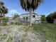 Rear exterior view of home with large deck, mature palm trees, and partial lawn area at 36 Forde Row, Charleston, SC 29412