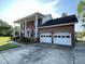 Brick home showing a two-car garage with a bright red front door and beautiful landscaping at 36 Forde Row, Charleston, SC 29412