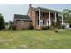 Beautiful brick home featuring a front porch with stately white columns and a well-manicured lawn at 36 Forde Row, Charleston, SC 29412